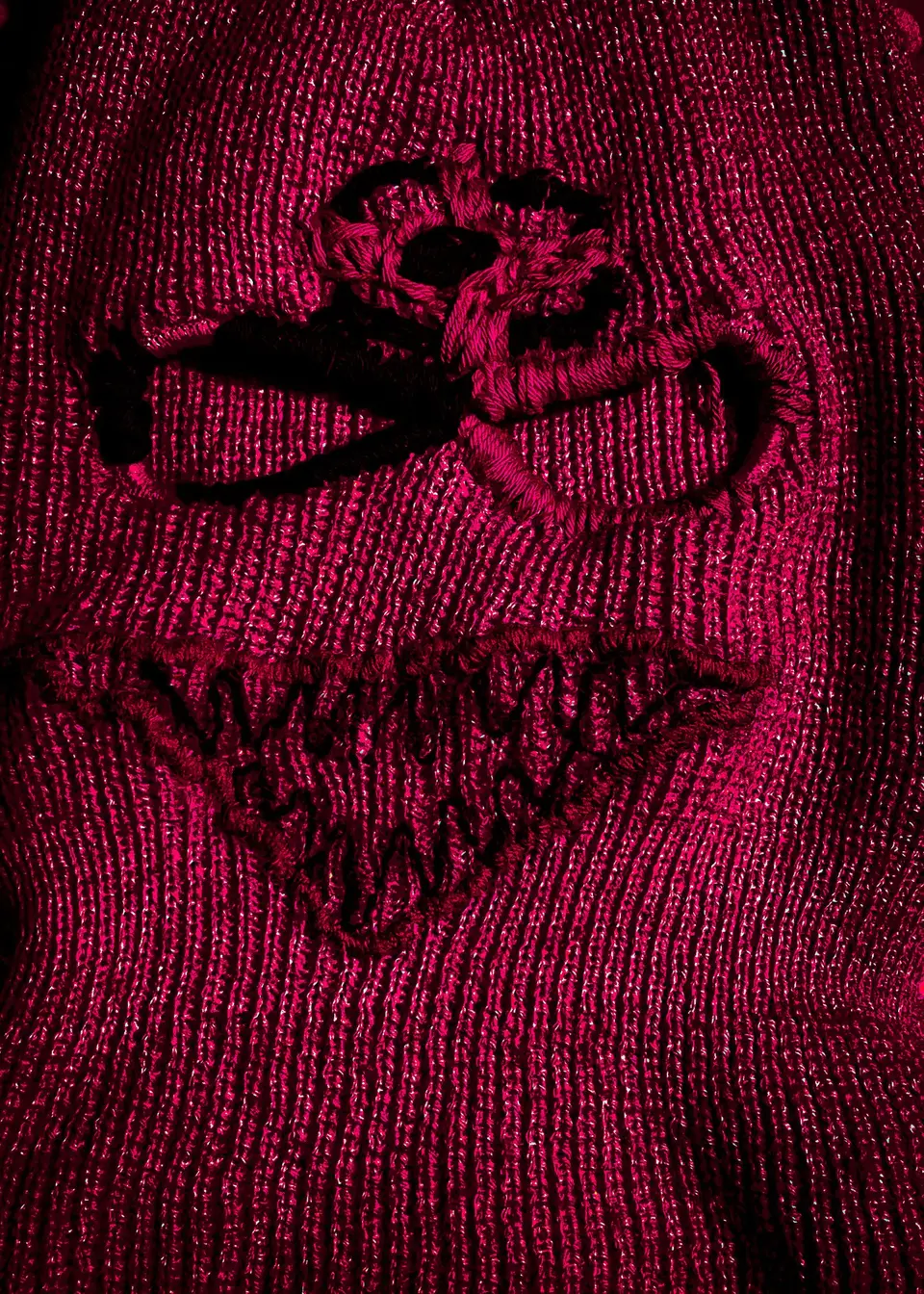 Cagoule nº 1 à plat, filtre rouge : contour brodé des yeux et bouche aux dents en zigzag